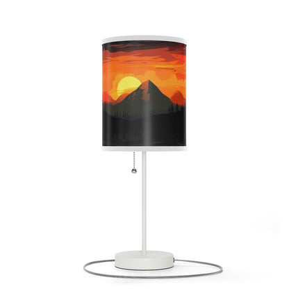 Sunset Silhouette - Lamp captures indoor sunset magic. With a realistic print of mountains and sunset, it bathes rooms in inviting hues. Radiant yet calming, its soft glow mimics natural sunsets, perfect for winding down. The lamp's 20" × 7" size, solid white steel base, and versatile design make it a charming addition to side tables, work desks, or nightstands.